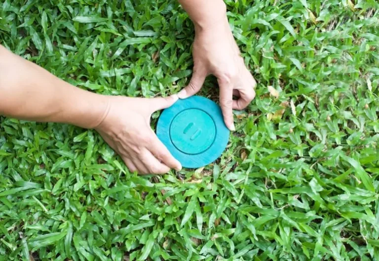 Pemasangan stasiun umpan rayap di area rumput untuk membantu mengendalikan koloni rayap